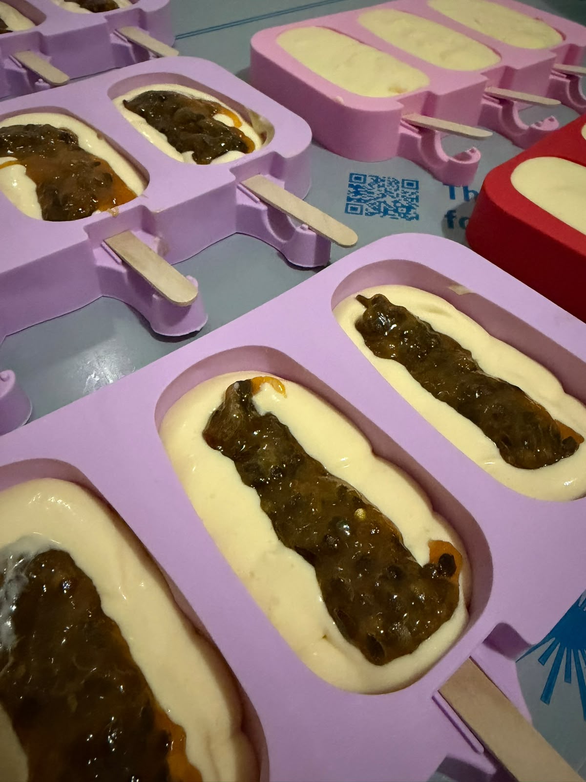 Picolés recheados sendo montados nas forminhas